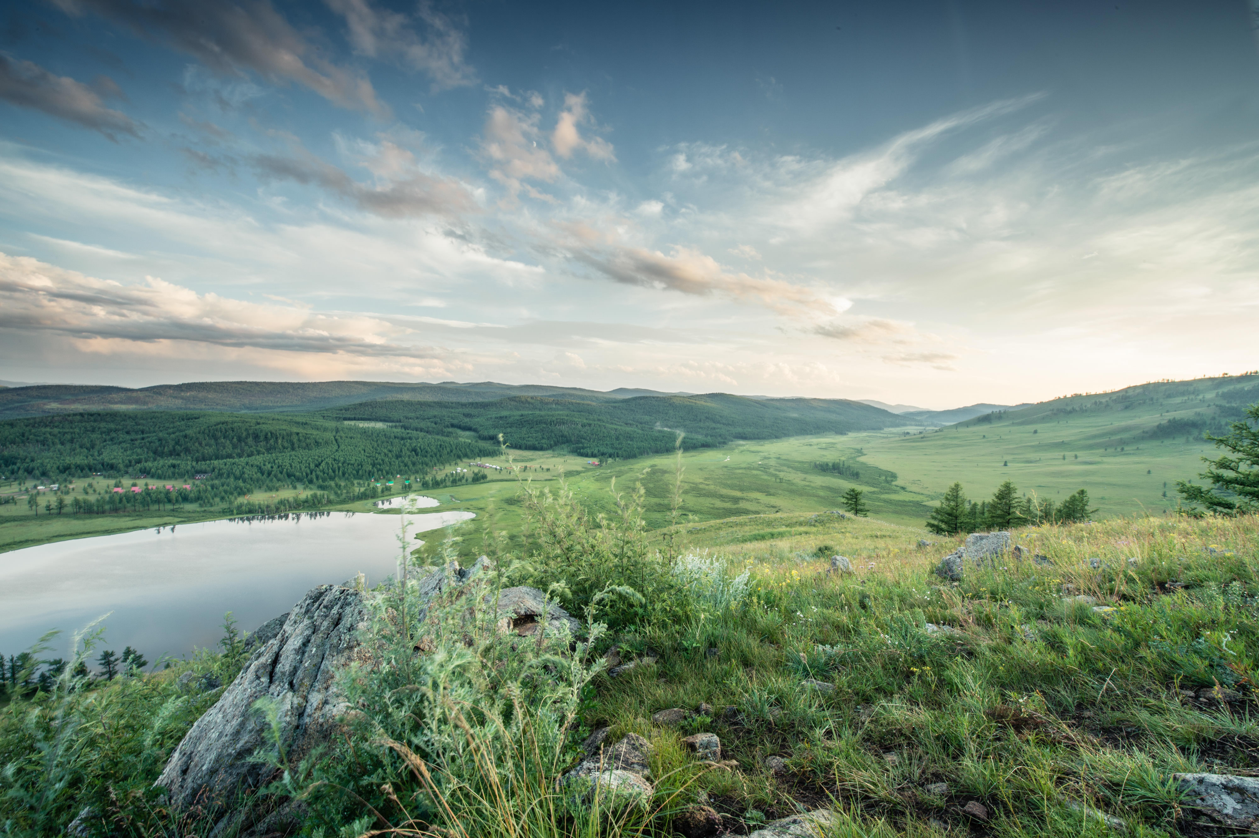 a view of a sweeping grassland landscape and cloudy sky